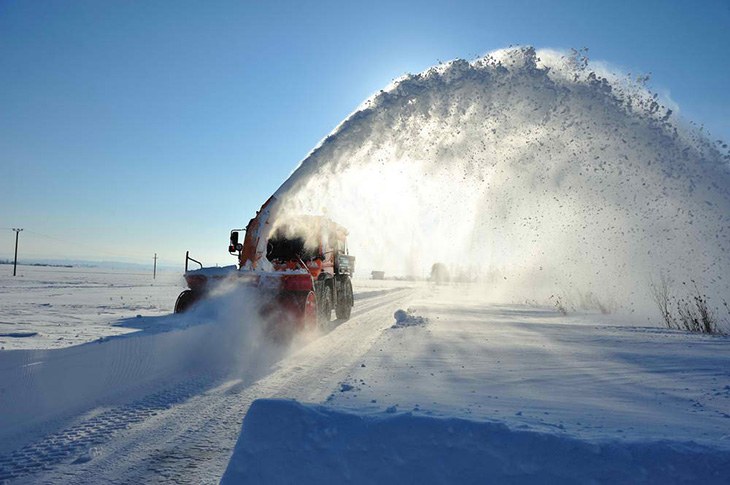 An all-terrain vehicle plowing deep snow