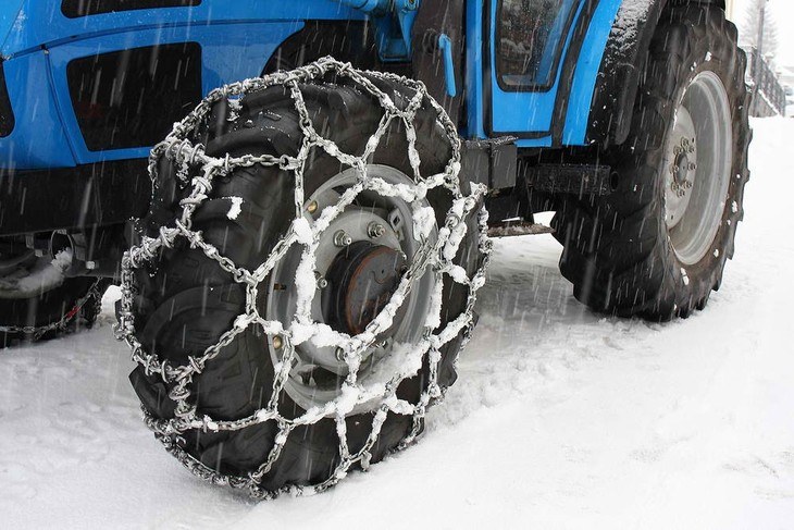 Snow chains cover the wheels of an all terrain tractor