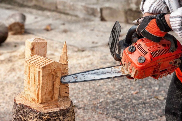 A wood sculptor uses a chainsaw as his tool for his project