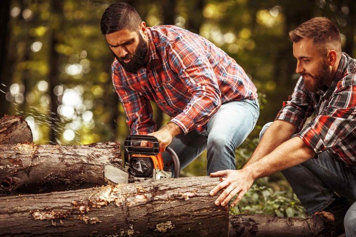 Two lumberjacks are cutting off a log for their cabin