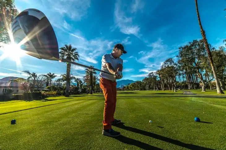 A golfer having a great time on a beautifully landscaped, soil compacted golf course