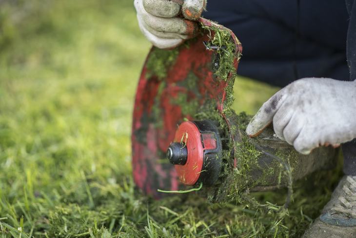 A string trimmer operates by moving it around the ground surface