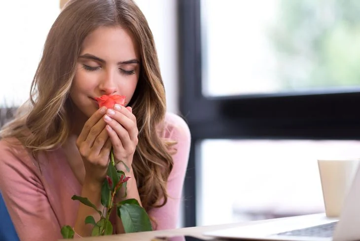 Woman holding a blooming red rose