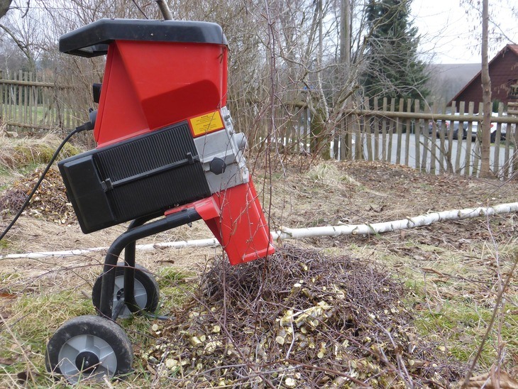 This electric chipper shredder is working on the twigs and other debris in the garden lot
