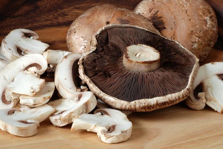 Close up of large Portobello mushrooms placed on wooden cutting board