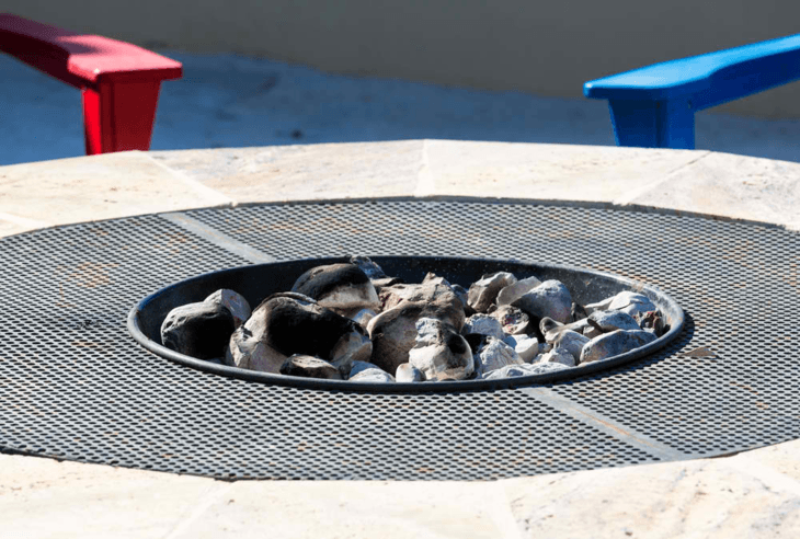 A standard propane fire pit with hot coals.
